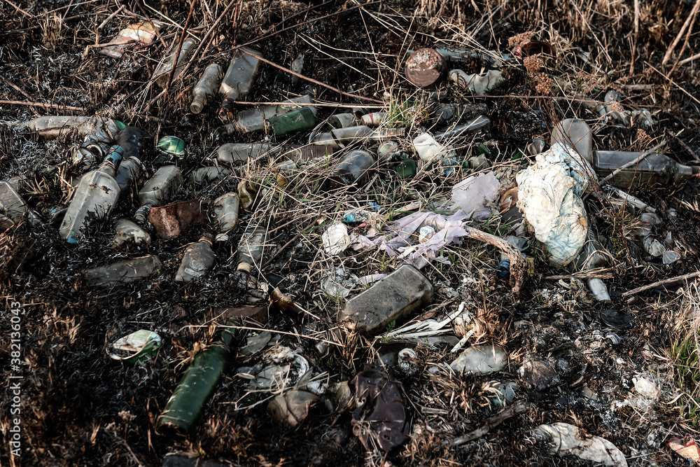 bottles and other garbage in the burnt grass