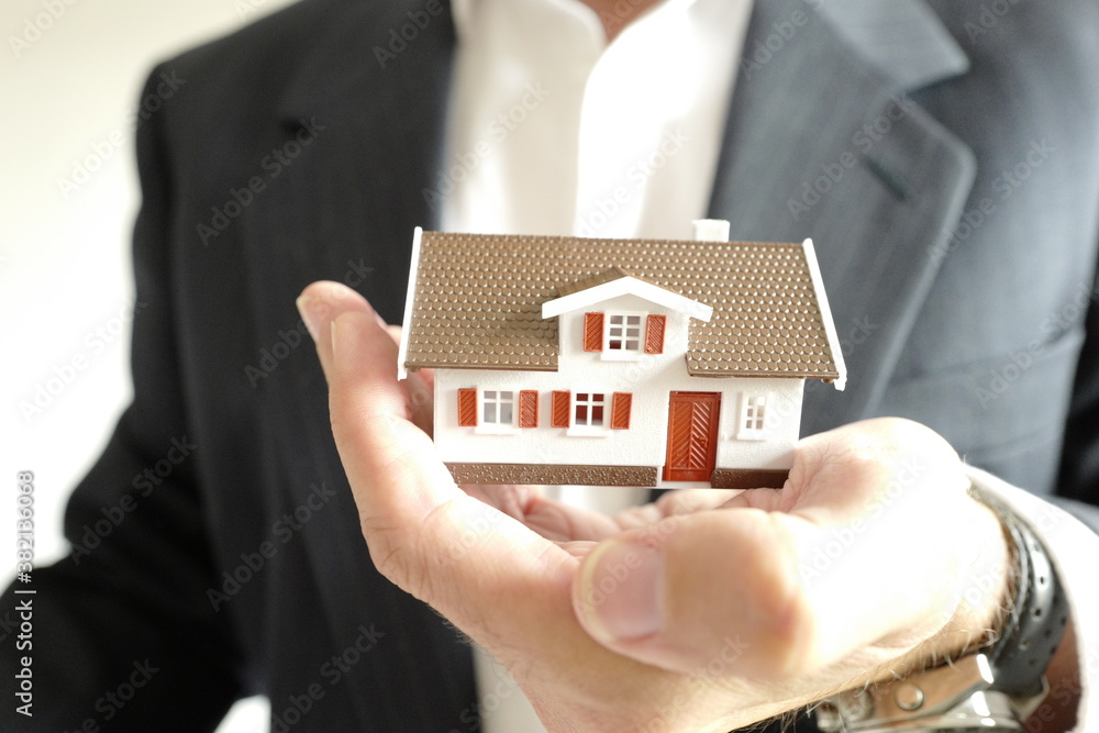 maison dans la main d'un homme en costume
