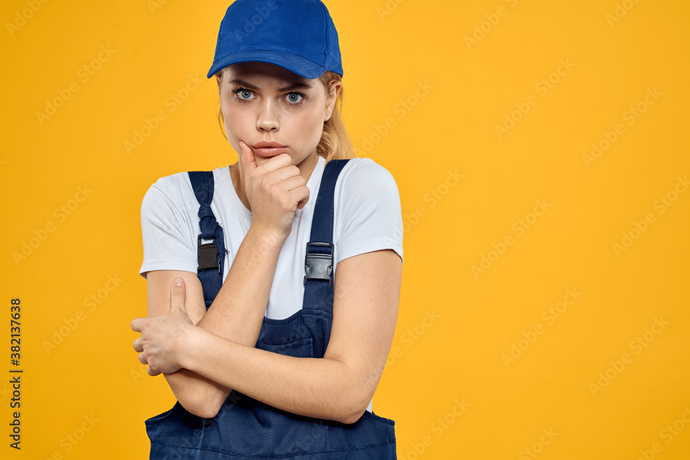 Woman in working uniform blue cap delivering courier service yellow background