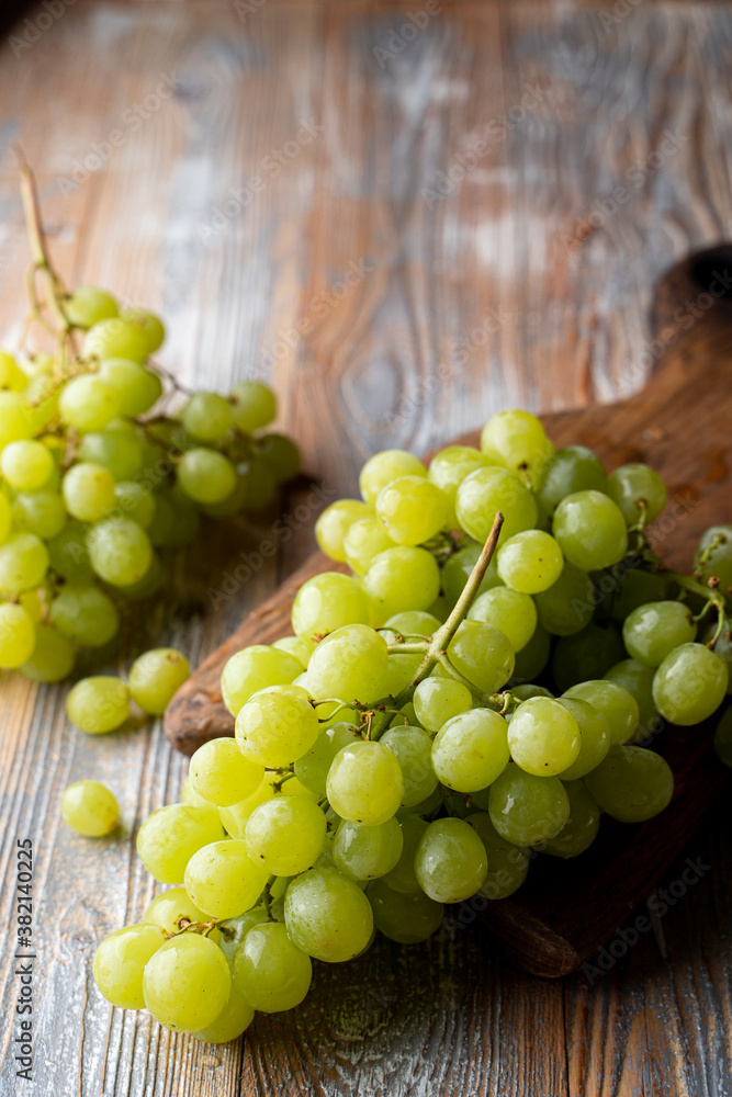 Green kishmish grapes on wooden table, close vibrant shot for grocery store Green kishmish grapes on wooden table, close vibrant shot for grocery store