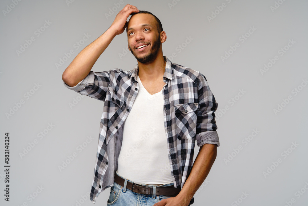 african-american young man wearing casual shirt over light grey background african-american young man wearing casual shirt over light grey background