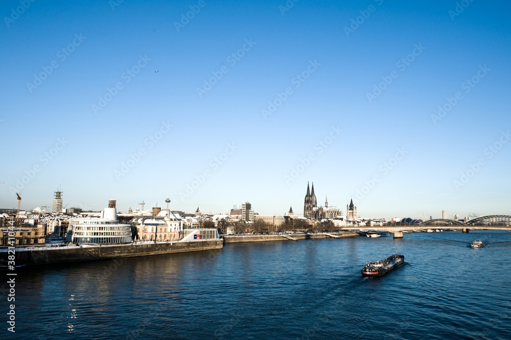 The river Rhine with the cathedral of Cologne in  Germany in winter with snow on a sunny day.