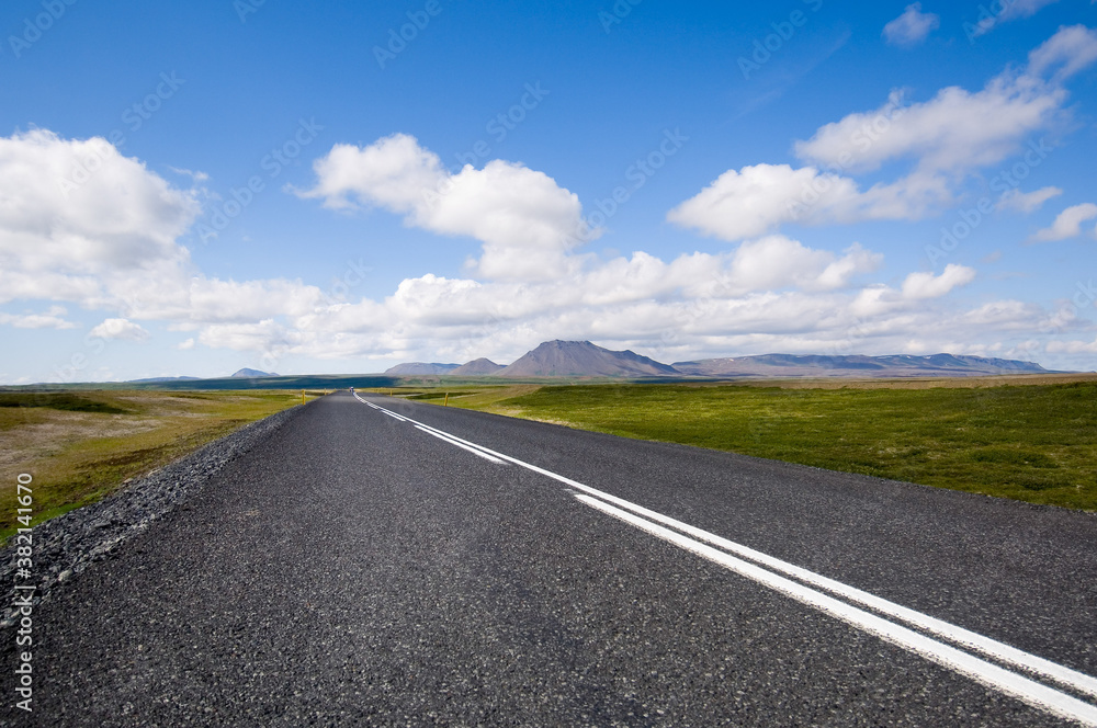 Clean asphalt road in island towards horizon with blue sky Clean asphalt road in island towards horizon with blue sky