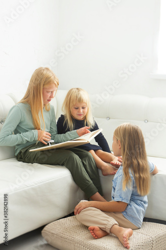 little child together reading a book on the sofa