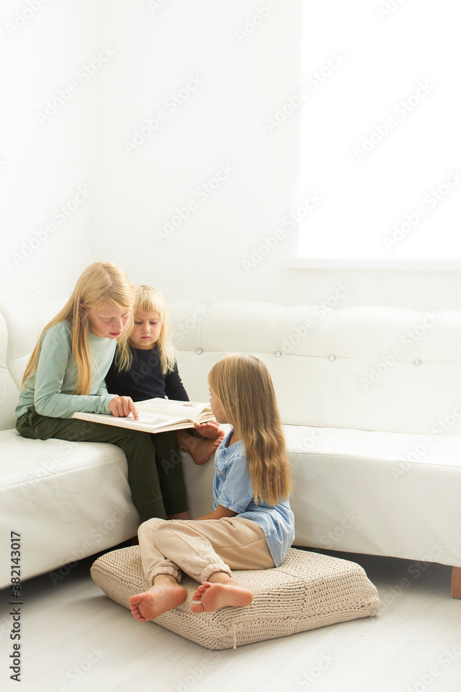 little child together reading a book on the sofa little child together reading a book on the sofa