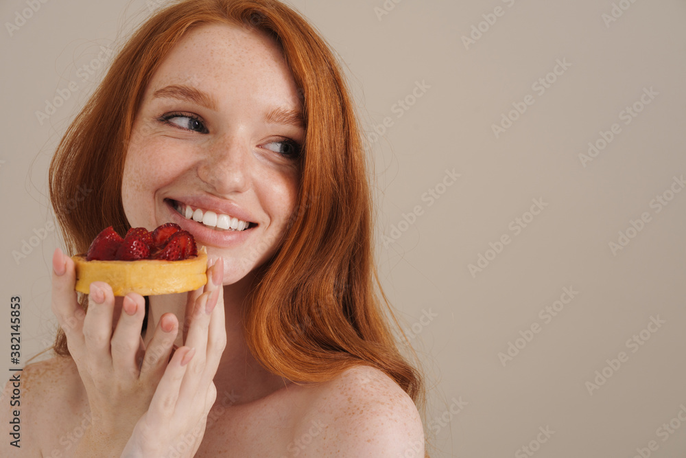 Photo of cheerful redhead shirtless girl posing with cake Photo of cheerful redhead shirtless girl posing with cake
