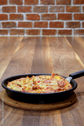 Italian Pizza in chopping board on a wooden table