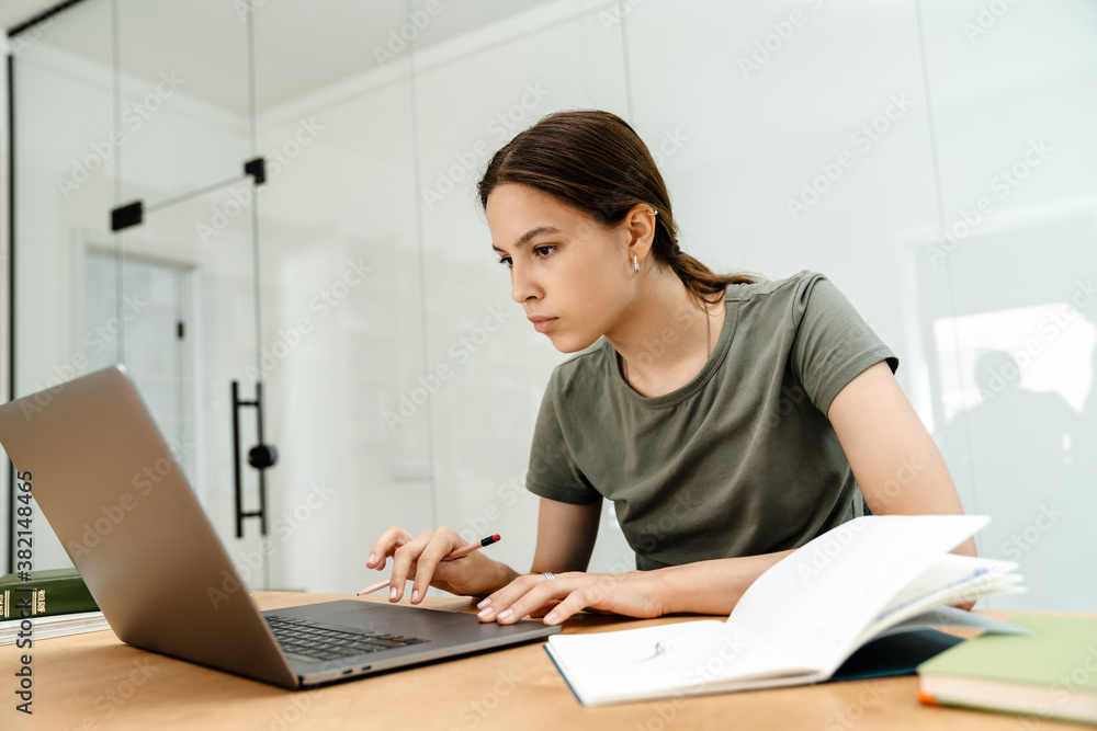 Image of thinking student girl doing homework with laptop Image of thinking student girl doing homework with laptop