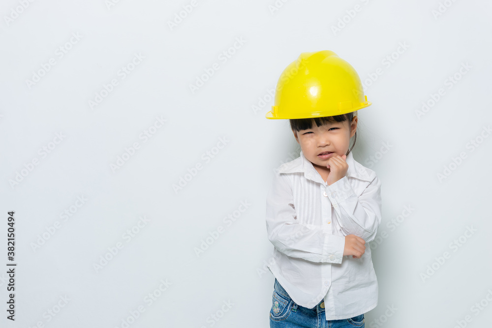 Portrait of cute asian little girl in engineer uniform and helmet on white background