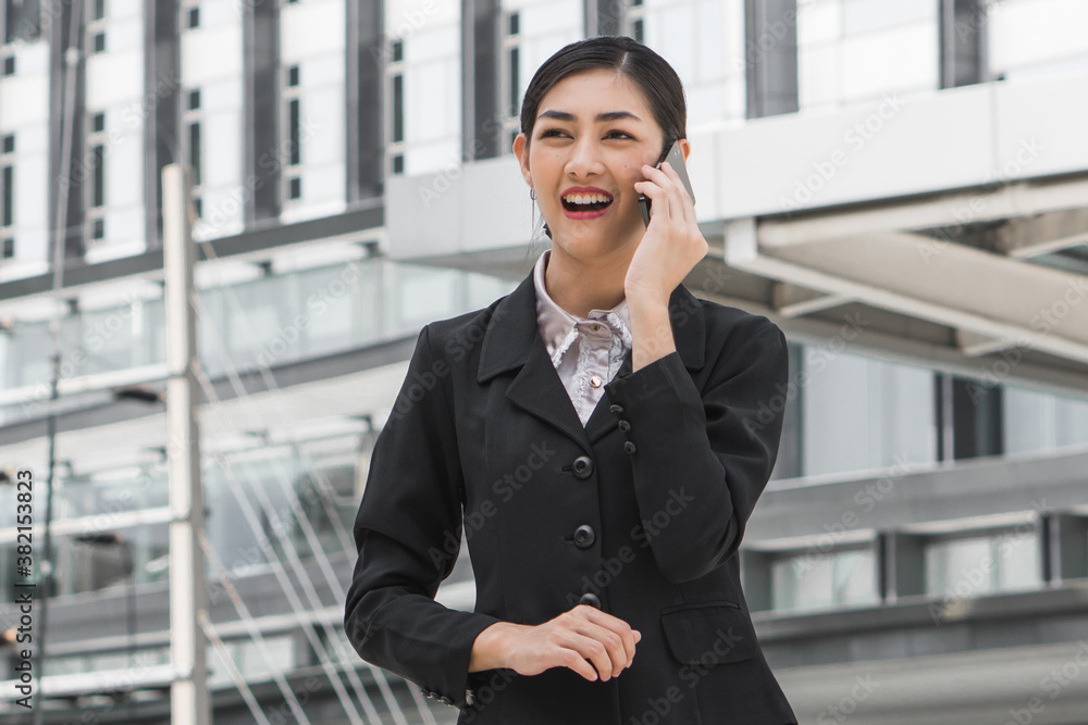 Asian woman calling on mobile in city town Asian woman calling on mobile in city town