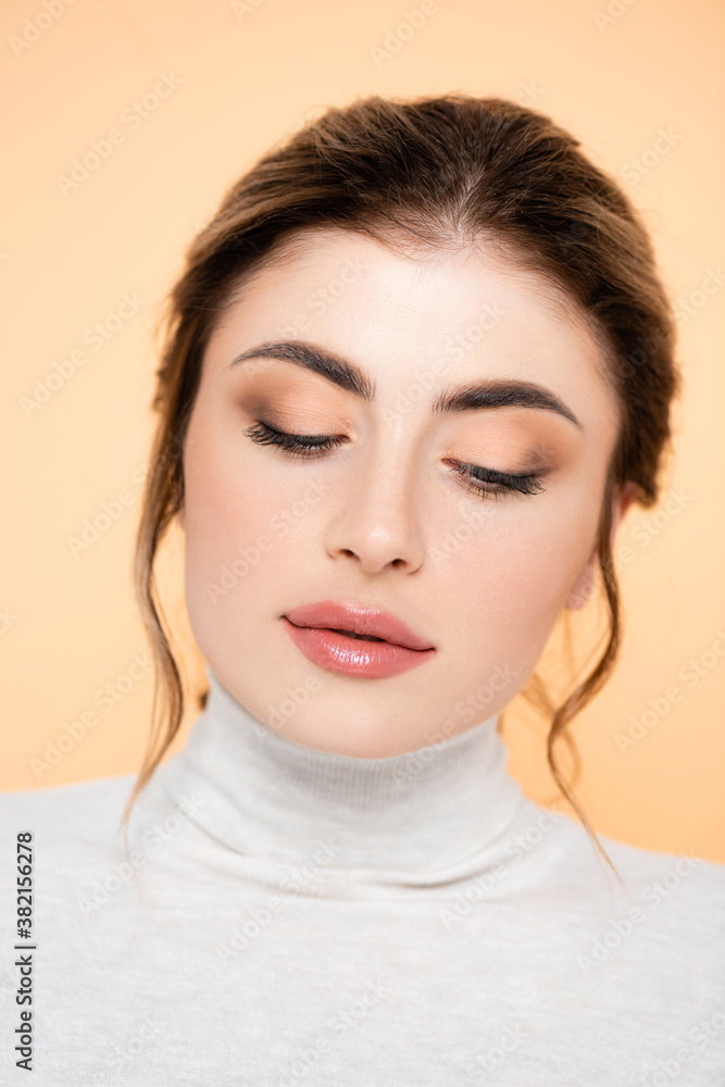 Fototapeta premium young woman in turtleneck posing isolated on peach