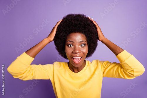 Portrait of astonished dark skin girl scream touch hands hairdo wear yellow pullover isolated on violet color background