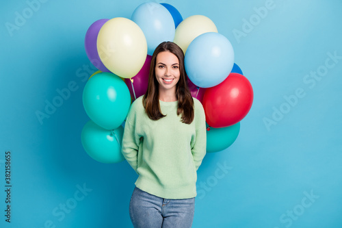 Photo portrait of female brunette student hiding pile of colorful balloons wearing casual outfit smiling isolated on vivid blue color background