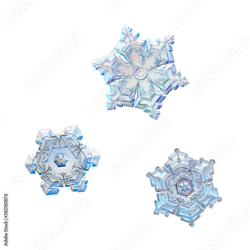 Three snowflakes isolated on white background. Macro photo of real snow crystals: elegant star plates with complex ornate shapes, hexagonal symmetry, short arms and glossy 3d surface.