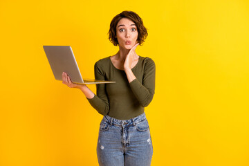 Photo of astonished lady hold laptop touch face with hand isolated over vivid yellow color background