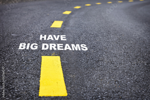 Have big dreams words on asphalt road surface with marking lines. Inspiration and motivation concept and effort idea © smshoot