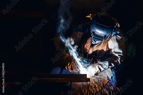 Industrial welder welding fabricated construction in factory, Welding process by Shielded Metal Arc Welding (SMAW) or Stick Welding. © sakarin14