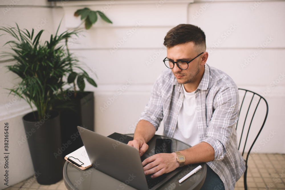 Concentrated man working on laptop in workspace Concentrated man working on laptop in workspace