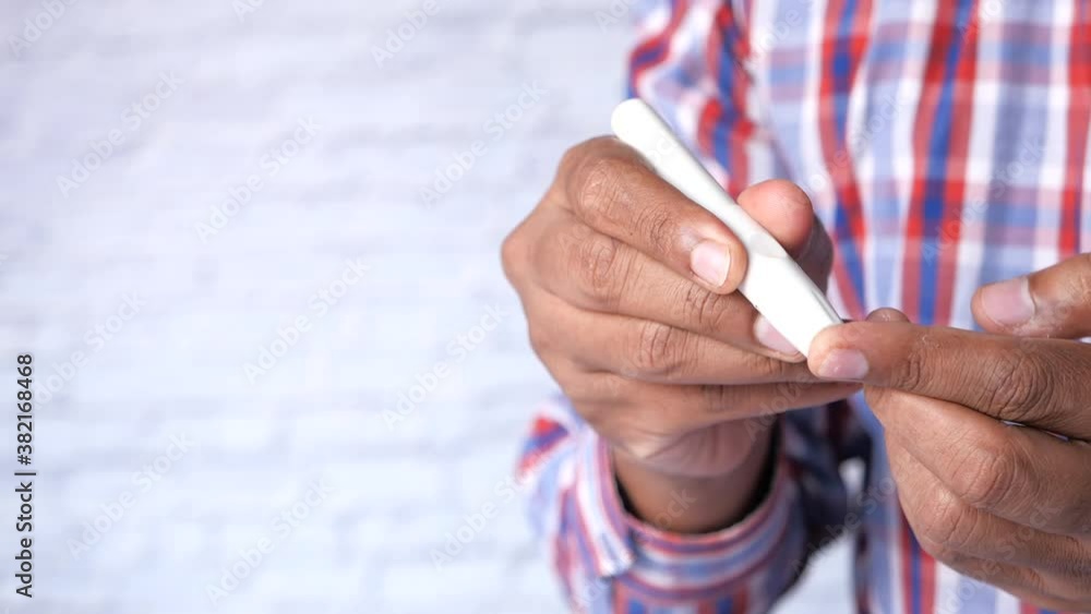 young man's hand measure glucose level at home young man's hand measure glucose level at home