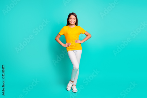 Full length photo of charming kid girl stand isolated over turquoise color background