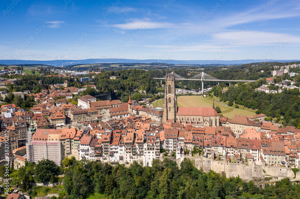 Aerial view of the Fribourg old town with its cathedral and the modern Poya bridge in Switzerland.