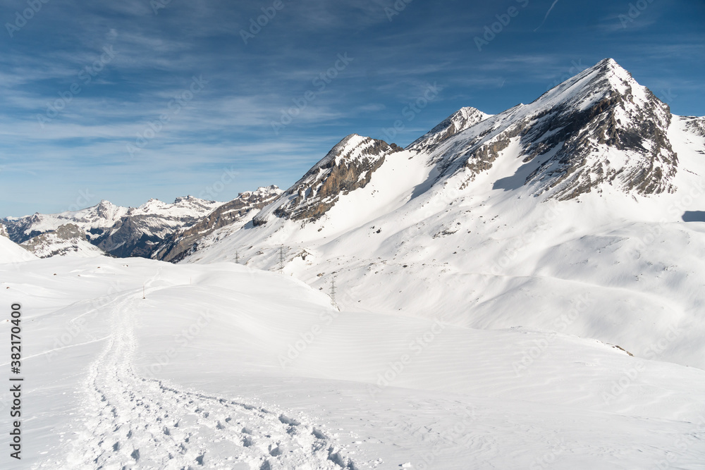 Snowshoes tracks on the gemmi pass near Leukerbad in Valais on a sunny winter day in Switzerland