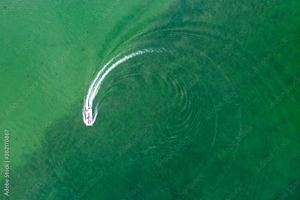 Aerial view of boat doing circles in green lake water Aerial view of boat doing circles in green lake water