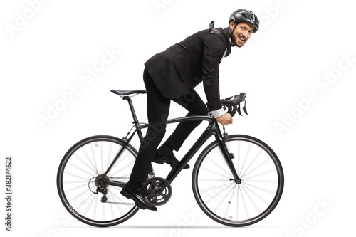 Profile shot of a man in a suit riding a bicycle to work