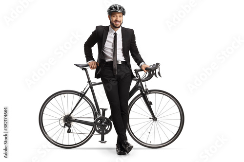 Businessman with a helmet leaning on a bicycle
