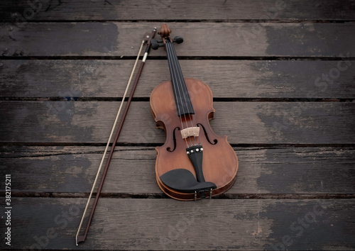 Violin and bow put on old wooden timber board,show detail of acoustic instrument © Watcharin