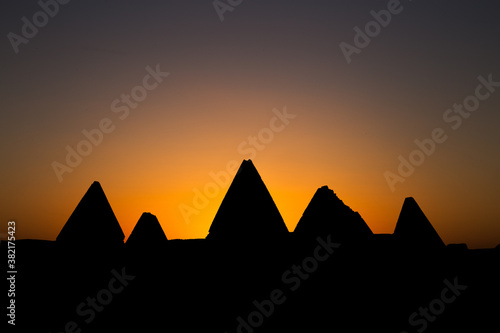 Silhouettes of pyramids in Sudan with sunrise background