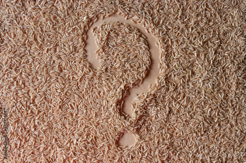 question mark sign ? on a brown rice background on plywood