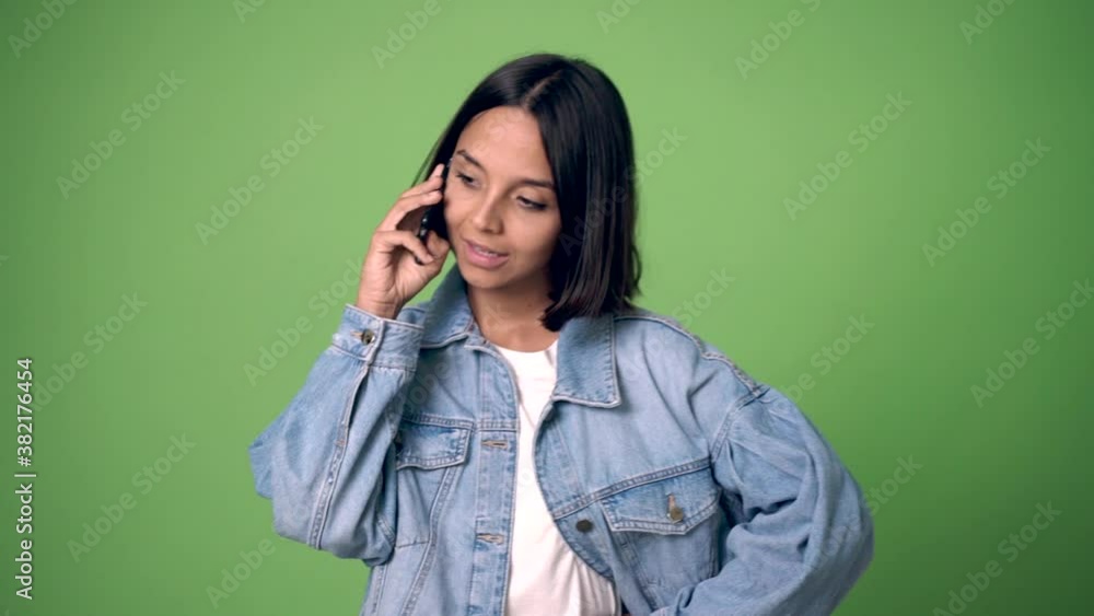 woman keeping a conversation with the mobile phone on green screen chroma key background woman keeping a conversation with the mobile phone on green screen chroma key background