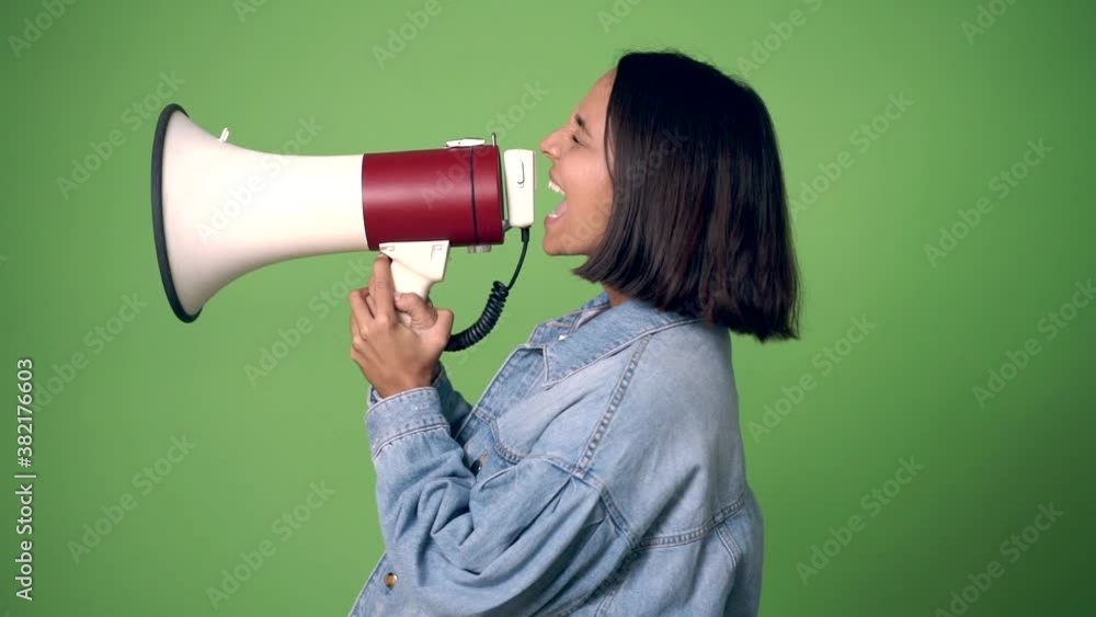 woman shouting through a megaphone on green screen chroma key background woman shouting through a megaphone on green screen chroma key background