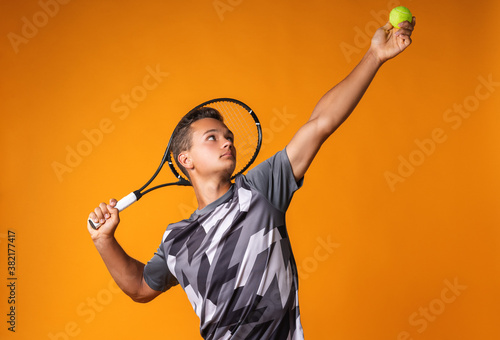 Portrait of a young man tennis player on orange background © fotofabrika