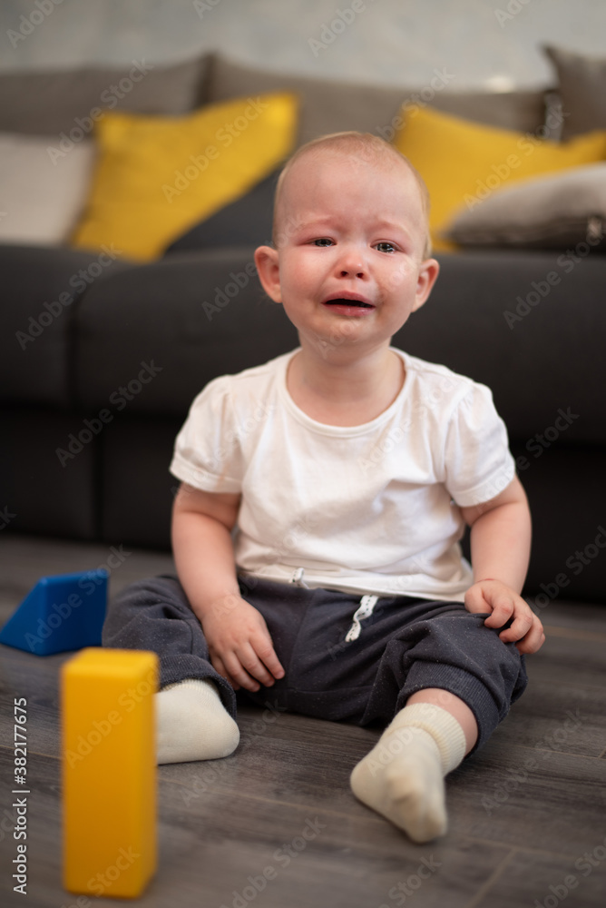 Little unhappy child crying on the floor in his room Little unhappy child crying on the floor in his room