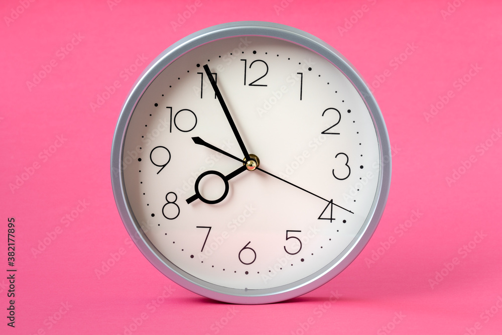 Time concept with clock on pink background Time concept with clock on pink background