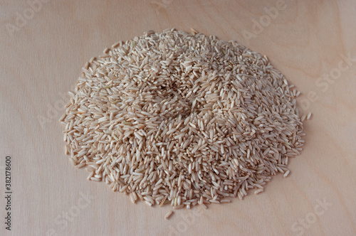 Brown rice on a plywood background