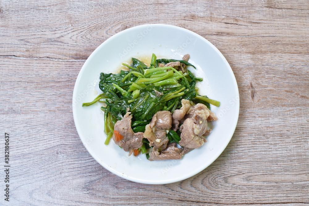 stir fried Chinese kale with slice pork in soybean sauce on plate stir fried Chinese kale with slice pork in soybean sauce on plate