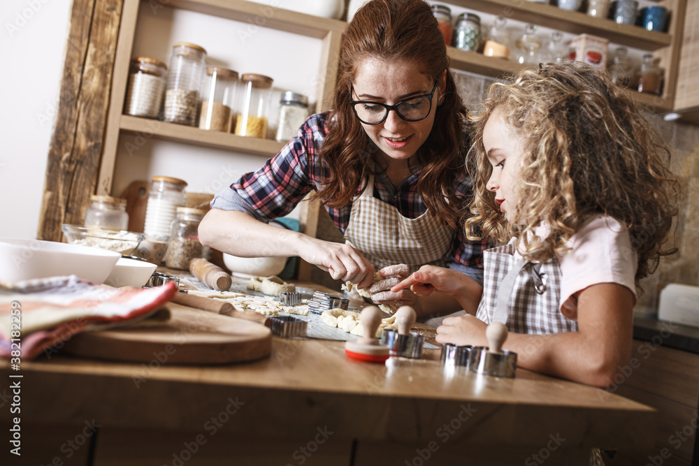 Fototapeta premium Mother and daughter playing and preparing dough in the kitchen.Family concept.