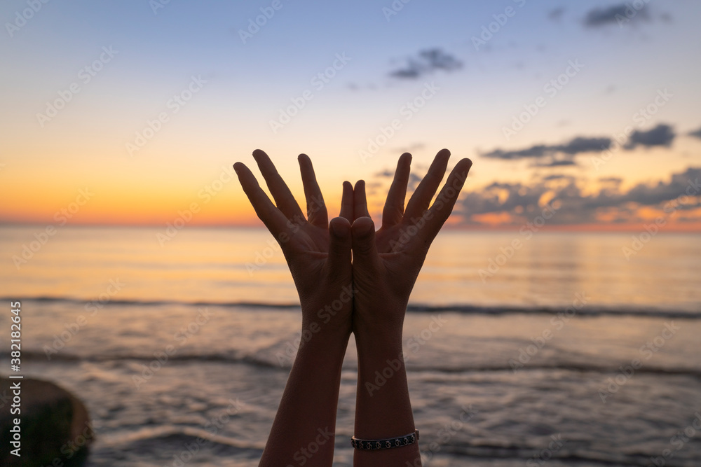 Healthy Lifestyle and Yoga Concept. Close-up hands. Woman do yoga outdoors at sunrise in lotus position. Woman exercising and meditating in morning. Namaste.