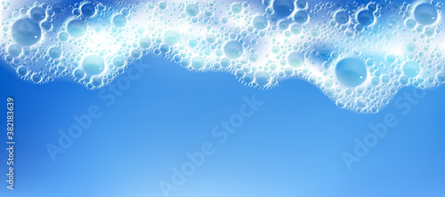 Cleaning foam with bubbles, white froth frame horizontal border, foamy texture, liquid soap or shampoo lather. Sea wave, laundry detergent spume isolated on blue background realistic 3d vector pattern photo