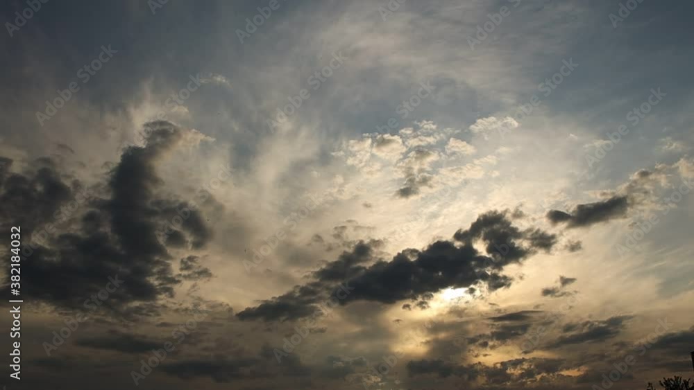 The evening sky with the sun peeking out from the dark clouds. Terrible mood. Low pressure and water flow in the atmosphere at sunset. Ecology of clean air. Weather forecast and meteorology. The evening sky with the sun peeking out from the dark clouds. Terrible mood. Low pressure and water flow in the atmosphere at sunset. Ecology of clean air. Weather forecast and meteorology.