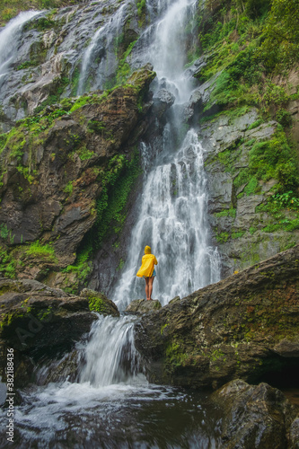 Woman standing on a rock with a waterfall in front