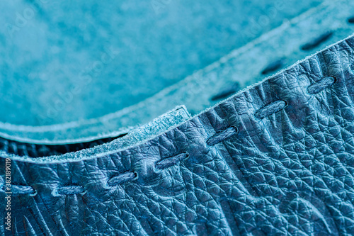 Fotografia Texture of blue genuine leather sewn with hand made sewing stitch