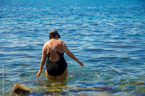Woman enter to sea water from the shore