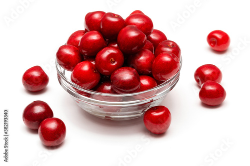 fresh black cherries in a glass plate on a white background