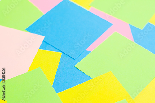 A set of office work related rainbow colored paper sticky notes. Isolated on cork background.