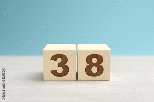 Wooden toy blocks forming the number 38.