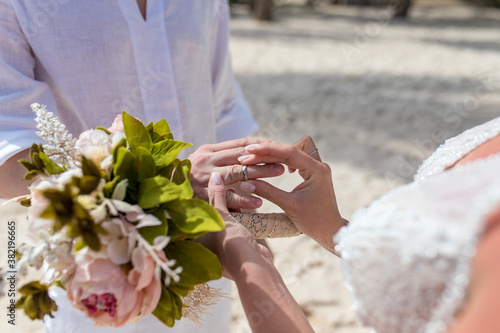 Fotografija Close up view of ring exchange at the wedding ceremony on the paradise beach, Pu